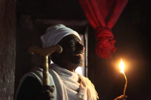 Priest holding traditional taper