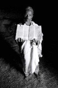 Priest holds bible - Mariam Buzuhan