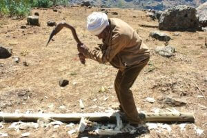 Farmer shaping wood for the doors and windows